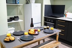 A breakfast setup with plates, croissants, a bottle, and juice glasses on a table. - #149 Stylish Apart. Near WestbourneCentre|Sleeps10 (Bournemouth)