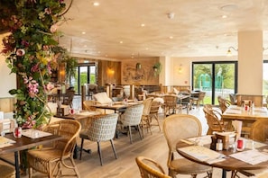 A restaurant with wicker furniture, large windows, and a view of greenery outside. - #149 Stylish Apart. Near WestbourneCentre|Sleeps10 (Bournemouth)