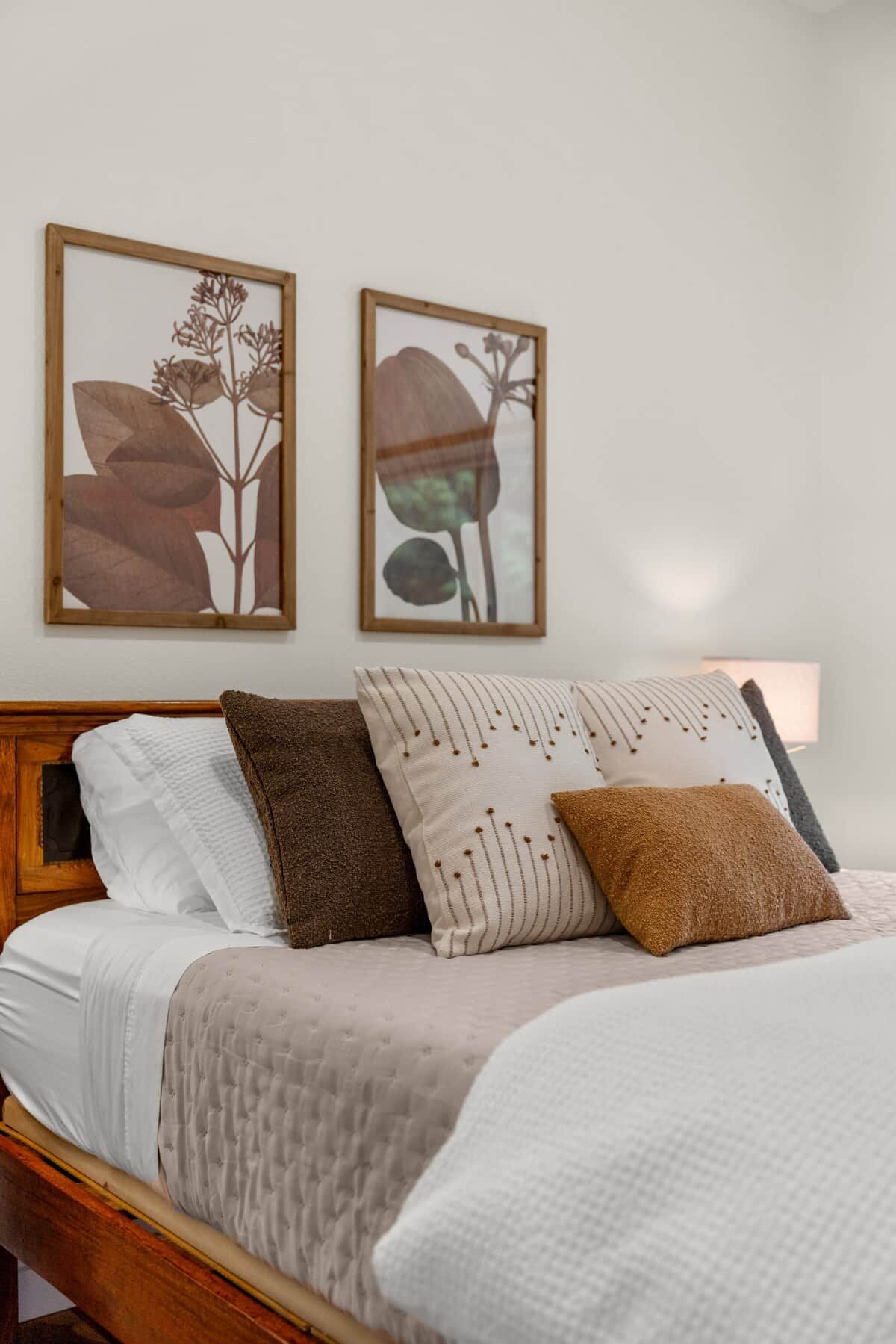 A bed with a wooden headboard, multiple pillows, and a white blanket.