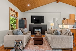 A living room with two sofas, a fireplace, and a television. - The Residence at Freshwater Bay (Port Angeles)