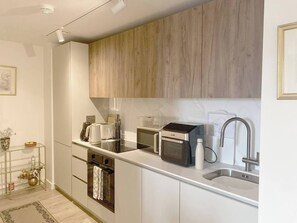 A modern kitchen with white cabinets, a stainless steel sink, a toaster, and a kettle. - #164 Coral retreat in Birmingham CC -Sleeps 6 (West Midlands)