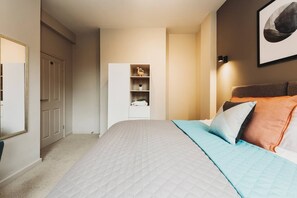 A bedroom with a bed, a wardrobe, and a mirror.