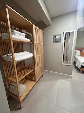 Ein Zimmer mit einem Holfischschrank, einem Bett mit weißer Daunendecke und einem Spiegel an der Wand.