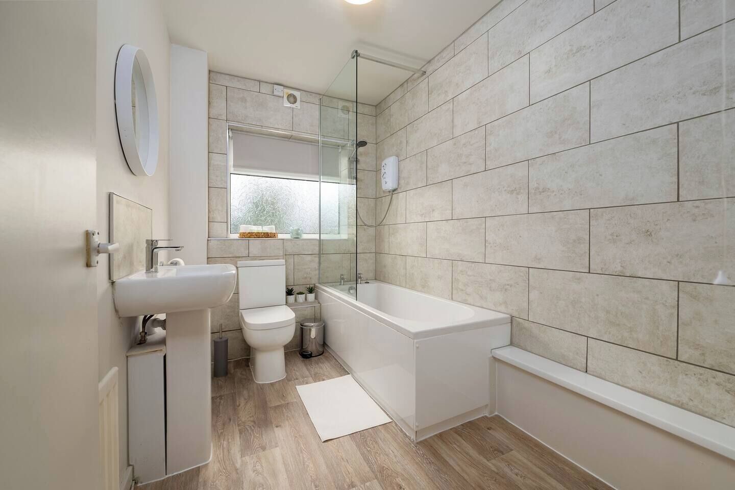 Un bagno moderno con toilette, lavandino e vasca da bagno.