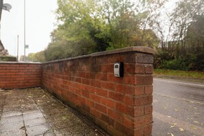 A brick wall with a security device mounted on it.