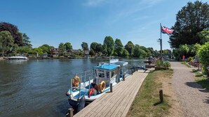 Een rivier met aanmerende boten, een houten steiger en een vlag.