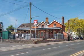 Edificio de estación de tren con un letrero rojo y blanco que indica 'Bourne End'.
