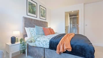 Une chambre moderne avec un lit, une table de chevet et un espace douche.