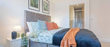 A modern bedroom with a bed, bedside table, and a shower area.