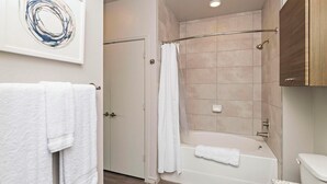 A bathroom with a shower, toilet, and a sink.