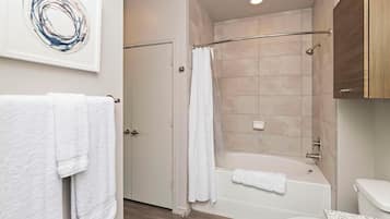 A bathroom with a shower, toilet, and a sink.