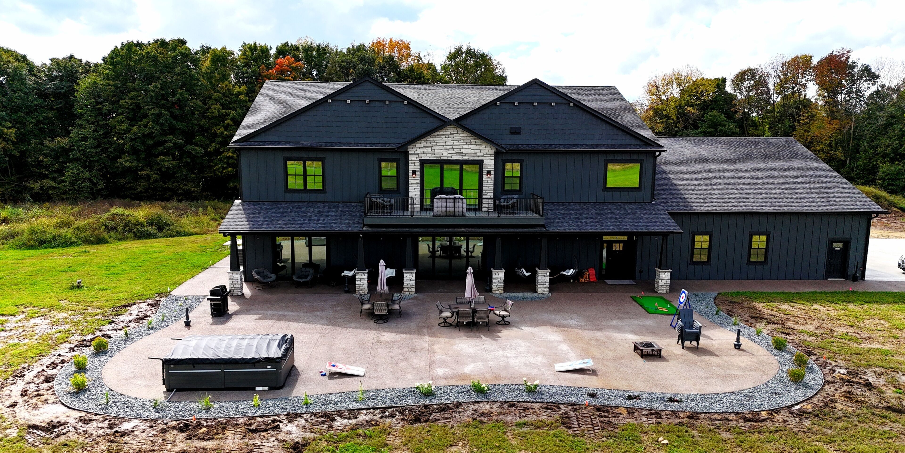 Une maison à deux étages dotée d’un patio couvert et d’une piscine.