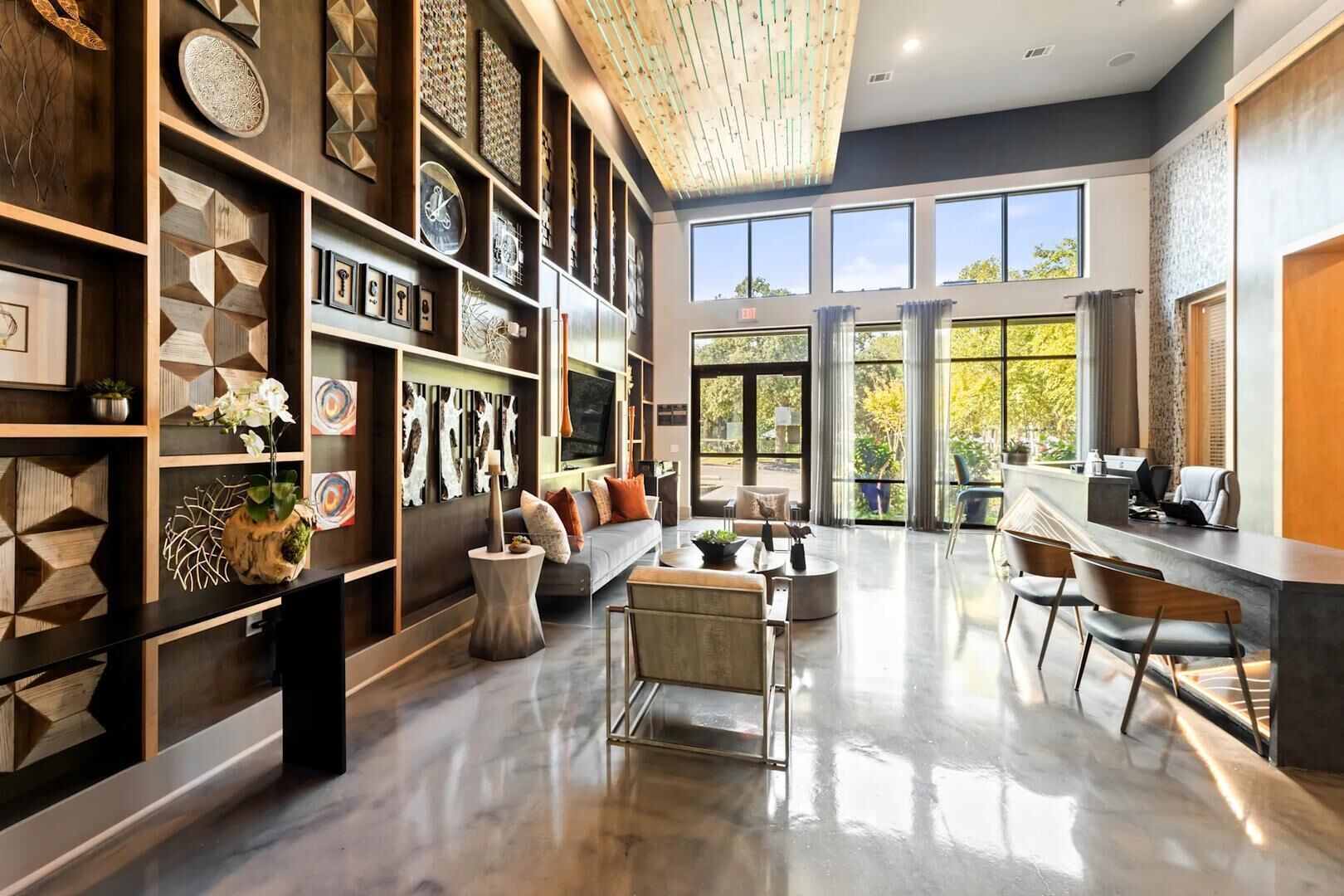 A spacious living area with a modern design, featuring a large sofa, a coffee table, and a dining area with chairs.