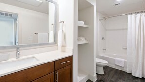 A modern bathroom with a large mirror, a sink, a toilet, and a shower area. - Landing Beautiful 1bd, Gym, Clubhouse (Houston)
