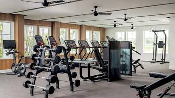A gym with various exercise equipment, including treadmills, weight machines, and a rowing machine.