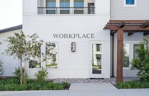 A building with a sign reading 'WORKPLACE' above the entrance, a wooden pergola, and a small tree in the foreground. - Landing Beautiful 1bd, Gym, Clubhouse (Port Charlotte)