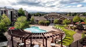Ein Wohngebiet mit Swimmingpool, Liegestühlen und einer Pergola.