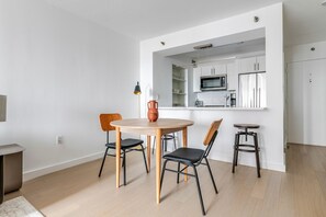 Cozinha moderna com armários brancos e um micro-ondas.