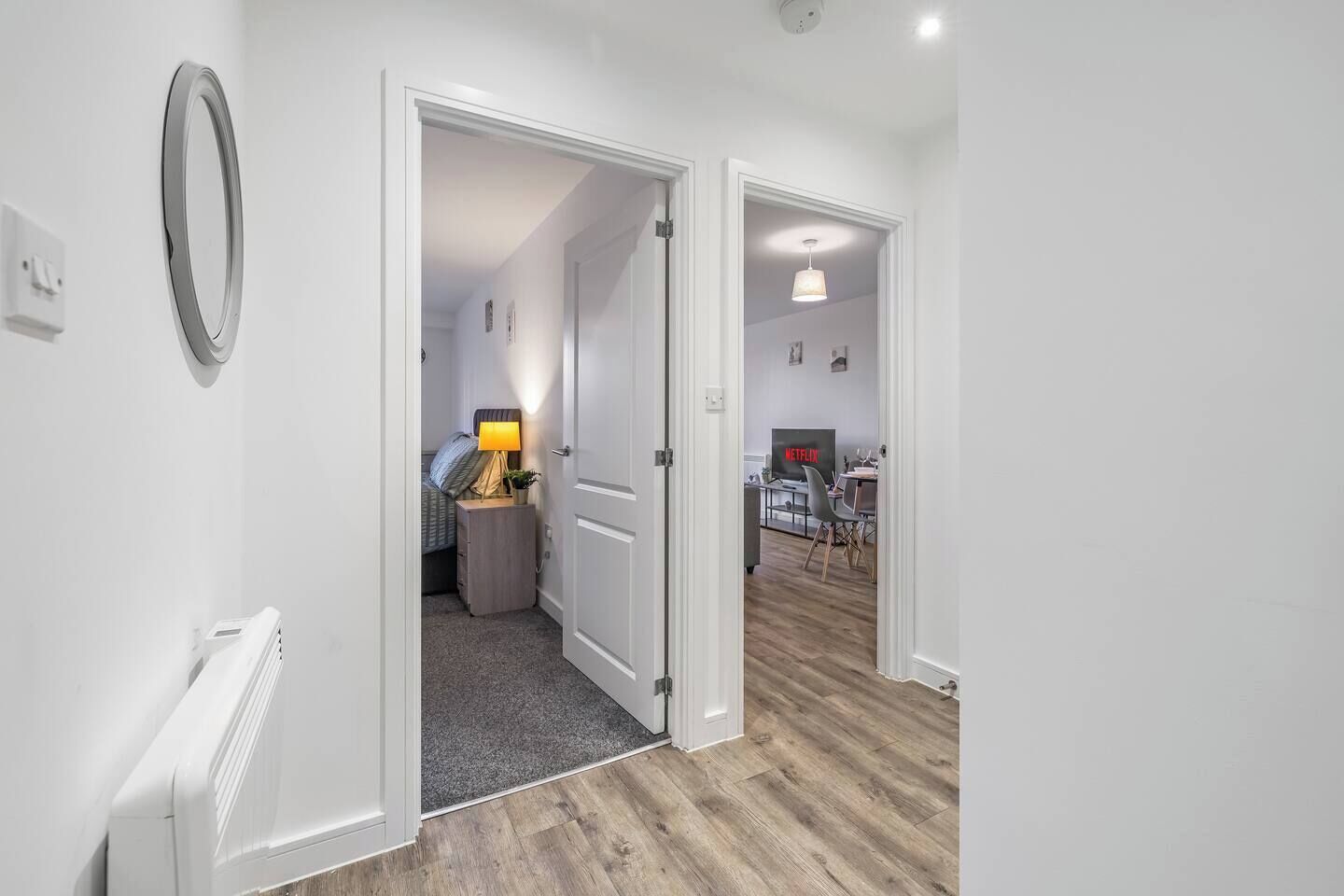A hallway with a door leading to a bedroom and a living area.