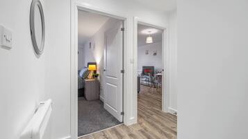 A hallway with a door leading to a bedroom and a living area.