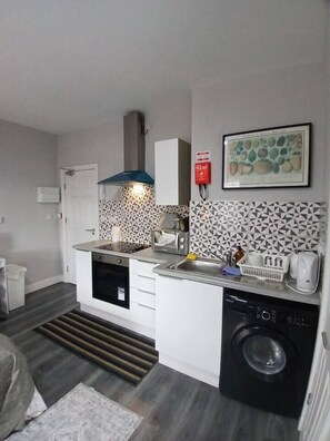 A compact kitchen with a dishwasher, a sink, and a microwave. - #68 Stylish Digbeth Studio 10 Apt City Centre (West Midlands)