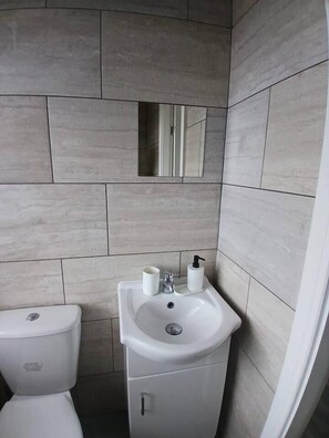 A bathroom with a toilet, sink, and a mirror on the wall. - #68 Stylish Digbeth Studio 10 Apt City Centre (West Midlands)