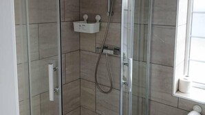 A glass-enclosed shower stall with a white towel rack and a toilet paper holder on the wall. - #68 Stylish Digbeth Studio 10 Apt City Centre (West Midlands)