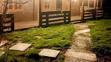 A wooden building with a porch and a gravel pathway leading to it.
