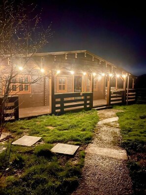 Ein Holzhaus mit Veranda und einem Kiesweg, der davorführt.