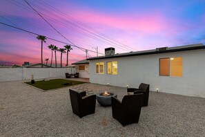 A modern outdoor patio with a fire pit, seating, and a view of the sunset. - Old Town Scottsdale Getaway  5BR • Sleeps 10 (Scottsdale)
