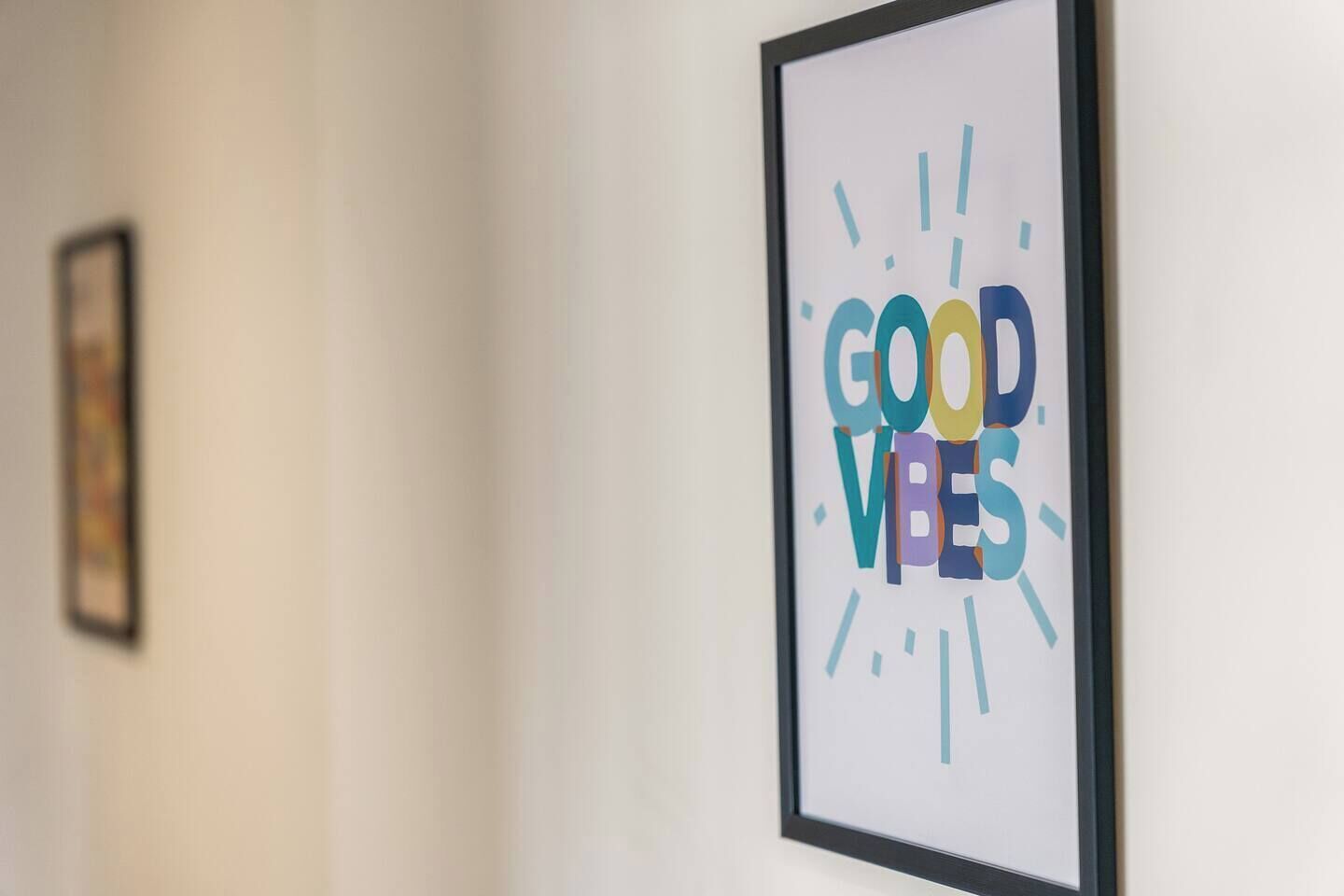 Une affiche encadrée avec le texte « BONNE AMBIANCE » accrochée à un mur.