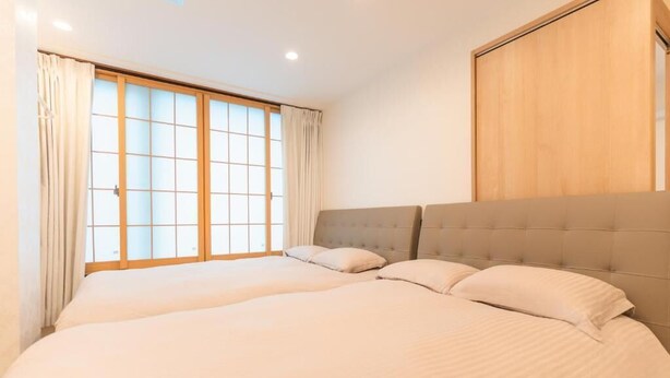 Ein Hotelzimmer mit einem großen Bett, einem Holz-Kopfteil und einer Schiebetür aus Glas.