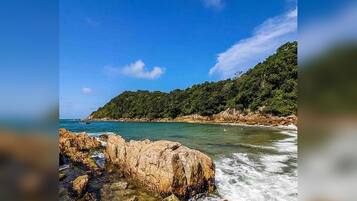 A coastal landscape with rocky terrain and a clear blue sky.