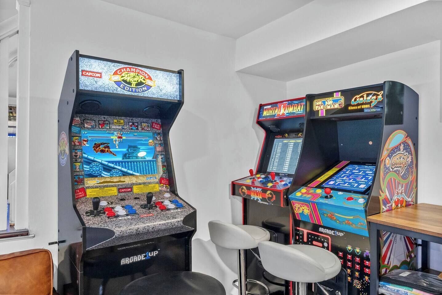 Une salle équipée de bornes d’arcade, notamment un modèle Capcom et une console Sega.