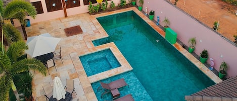 A rooftop swimming pool with multiple sections and surrounding lounge areas.