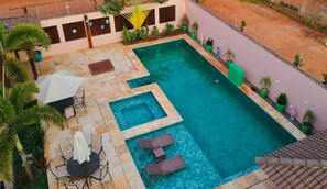 A rooftop swimming pool with multiple sections and surrounding lounge areas. - 4let Chales Sonho de Verão (São Miguel do Gostoso)