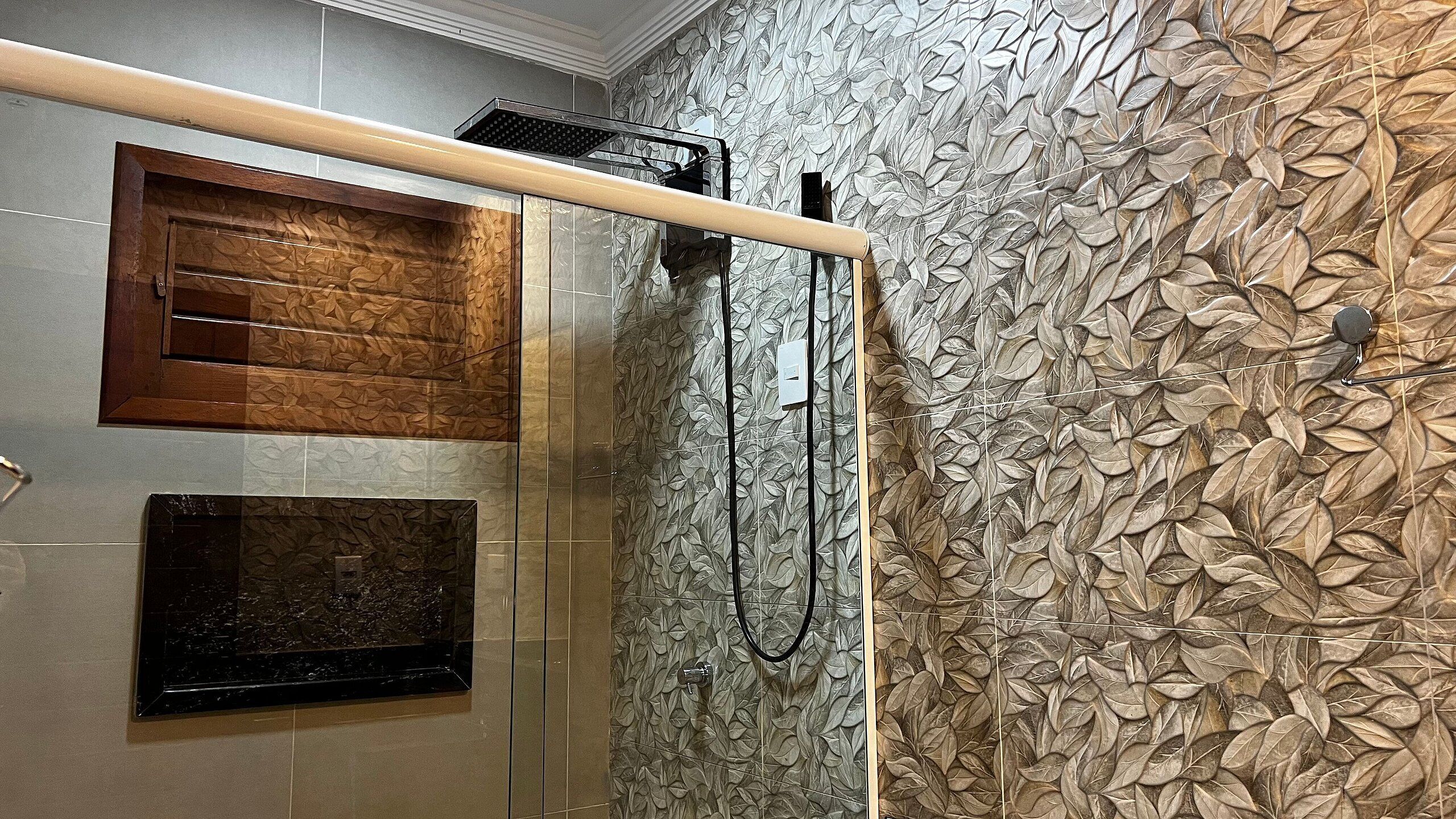 Une douche avec un panneau en bois et un mur à motifs de feuilles en relief.