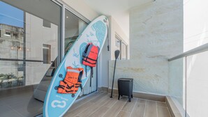 Un balcone con un’asse da surf, un remo e un cestino.