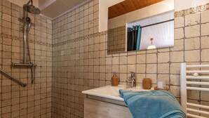 Ein Badezimmer mit Dusche, Waschbecken und Spiegel.