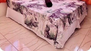 Een slaapkamer met een bed, kussens en gordijnen.