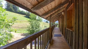 Eine hölzerne Veranda mit Blick auf eine grüne Landschaft.