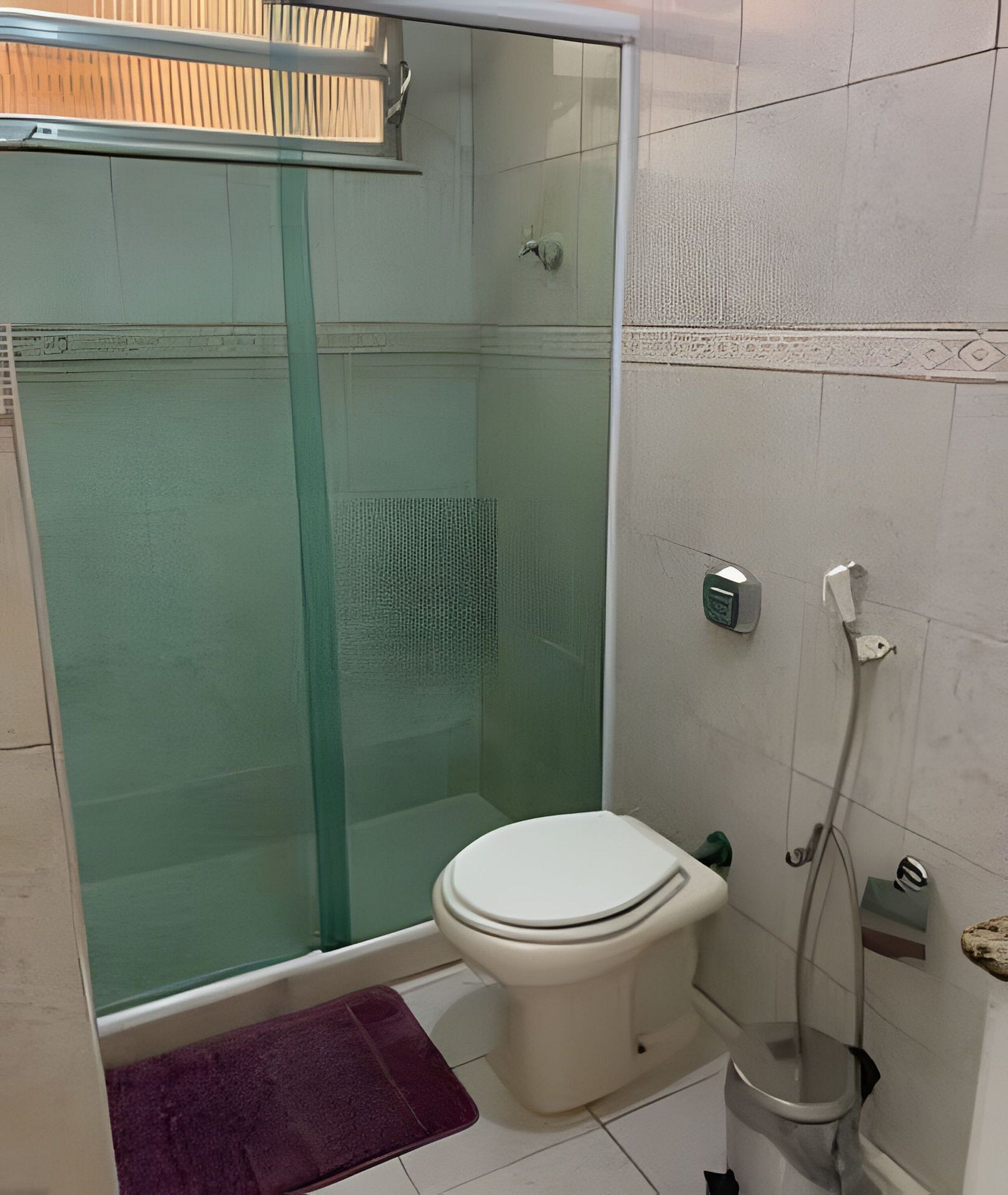 Un bagno con doccia vetrata, un water e un bidet.