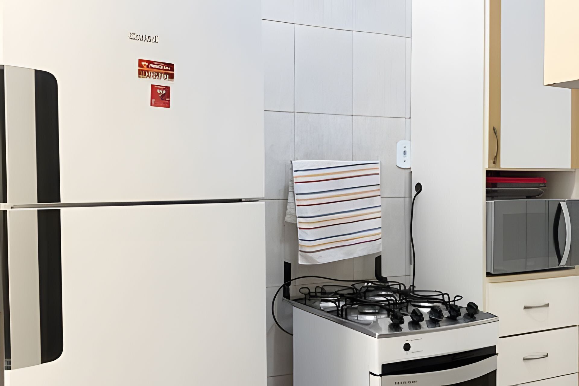 A kitchen with a white refrigerator, a gas stove, and a microwave.