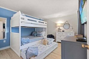 A bunk bed room with a desk and a television. - Luxury Oceanfront 3BR | Stunning Beach Views (North Myrtle Beach)