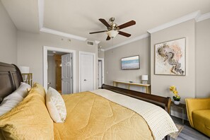 Ein Hotelzimmer mit einem Bett, einem Deckenventilator, einem Fernseher und Bildern an der Wand.