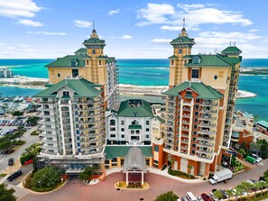 A large hotel with multiple towers, a central courtyard, and a view of the ocean. - 3BR Harborfront Condo - Pool, Hot Tub, Bay Shuttle (Destin)