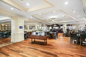 A spacious hotel lobby with wooden flooring, multiple seating areas, and a bar. - 3BR Harborfront Condo - Pool, Hot Tub, Bay Shuttle (Destin)