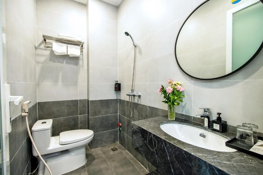 A modern bathroom with a toilet, shower, and sink.