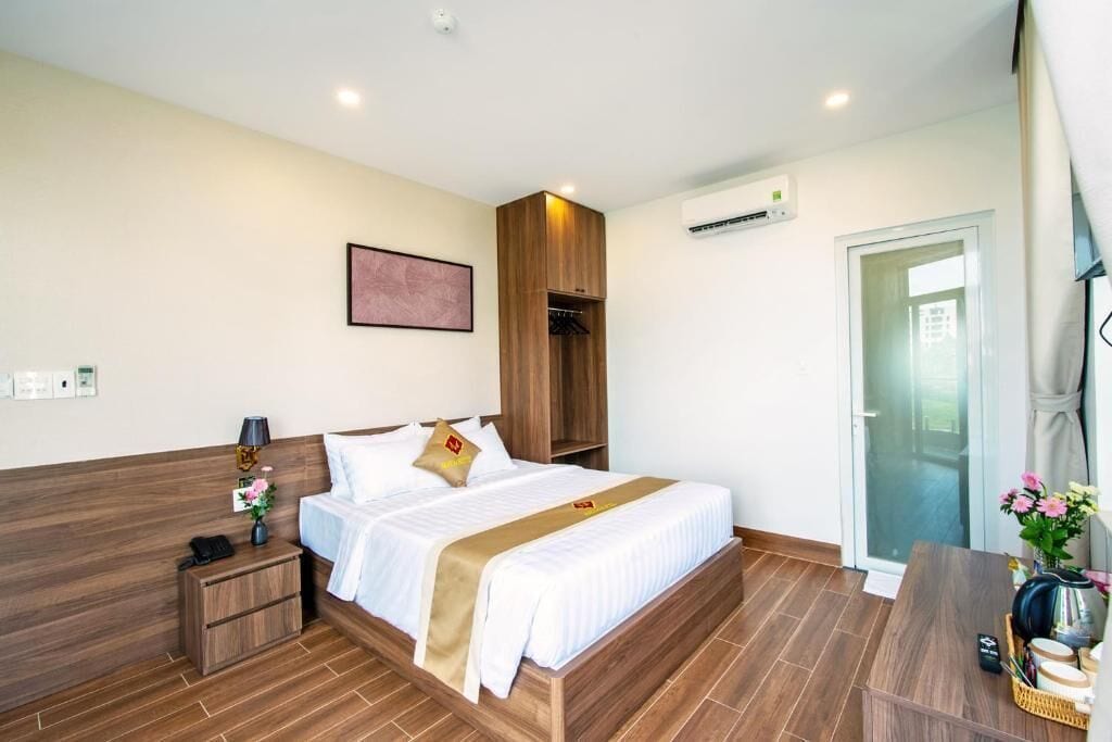 Ein Hotelzimmer mit Bett, Nachttisch, kleiner Schreibtisch und Stuhl.