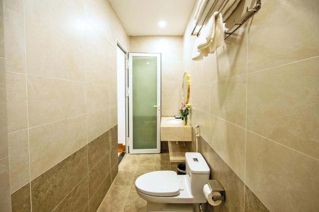A compact bathroom with a toilet, sink, and a glass shower door.